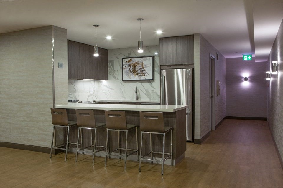 A modern kitchen with a bar area and stools.