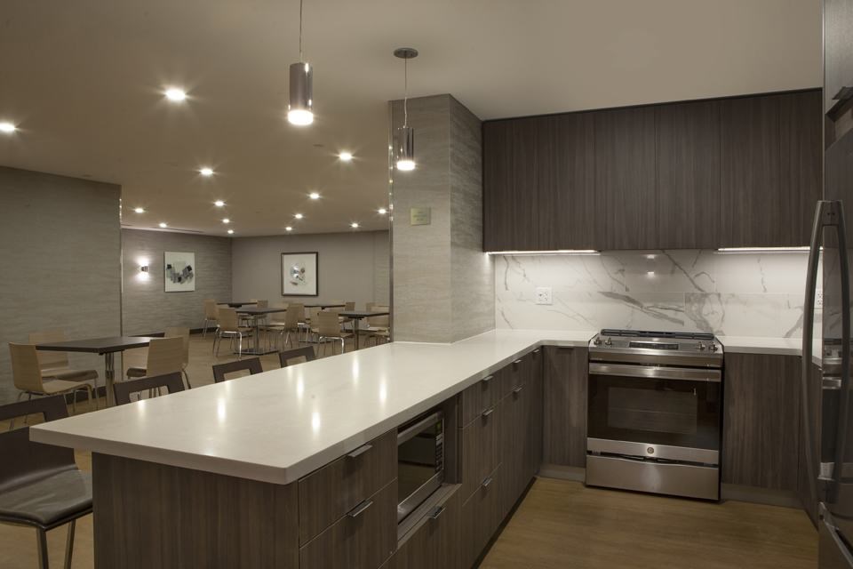 A modern kitchen with a large island and stainless steel appliances.