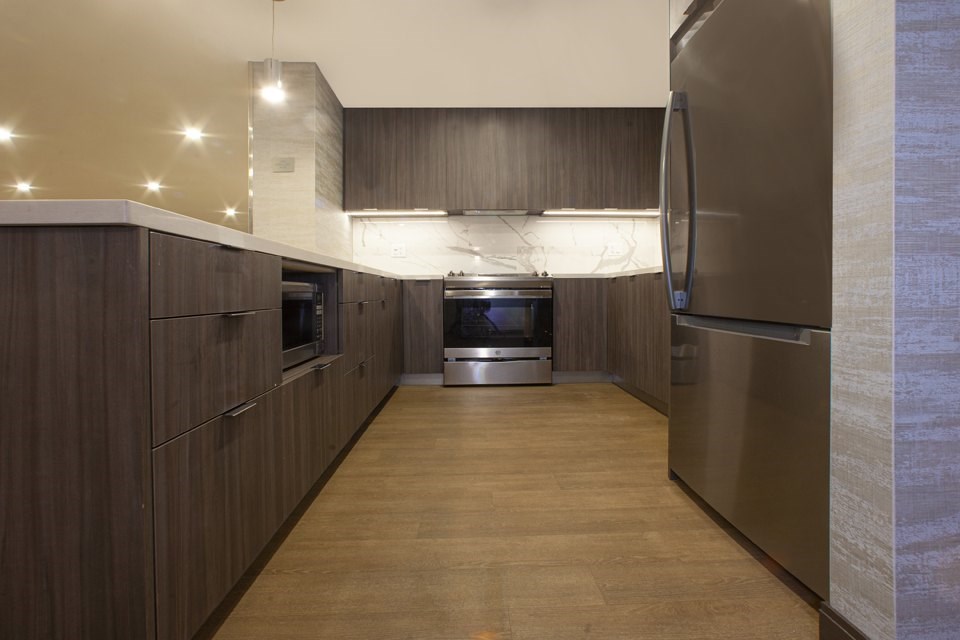 A modern kitchen with wooden cabinets and stainless steel appliances.
