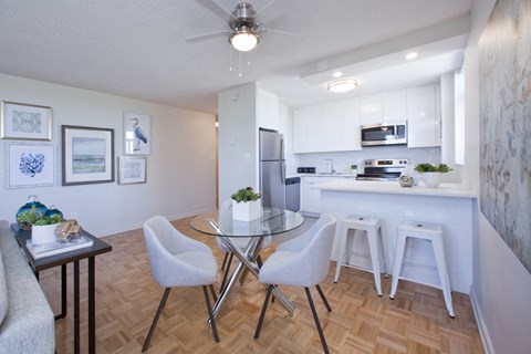 an open kitchen and dining room with a glass table and chairs