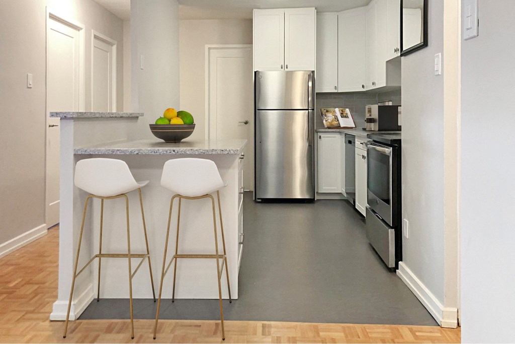 a kitchen with stainless steel appliances and a counter with bar stools