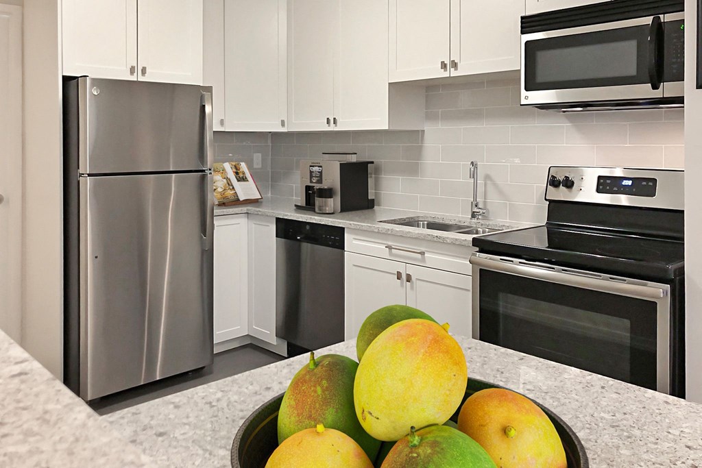 a kitchen with stainless steel appliances and a bowl of fruit