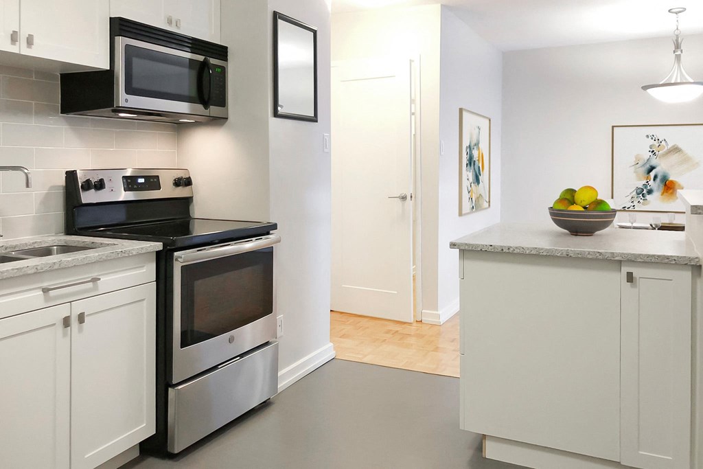 a kitchen with stainless steel appliances and a counter with a sink and a microwave