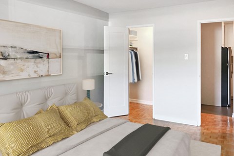 a bedroom with a bed and a closet and a painting on the wall