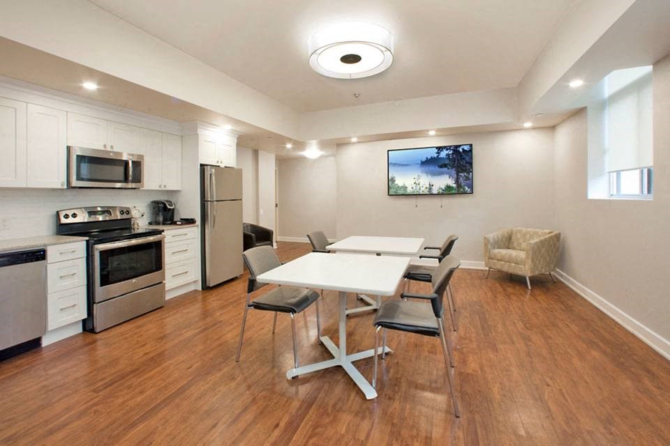 Cedarwoods Tower in Kitchener, ON social room with stainless steel appliances and dining set