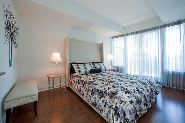 Bedroom with a dogtooth pattern on the comforter of the bed at Cityview Apartments in Brampton, ON