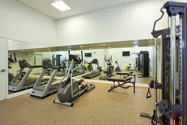 Cityview Apartments Fitness center with big mirror walls and weight lifting equipment in Brampton, ON