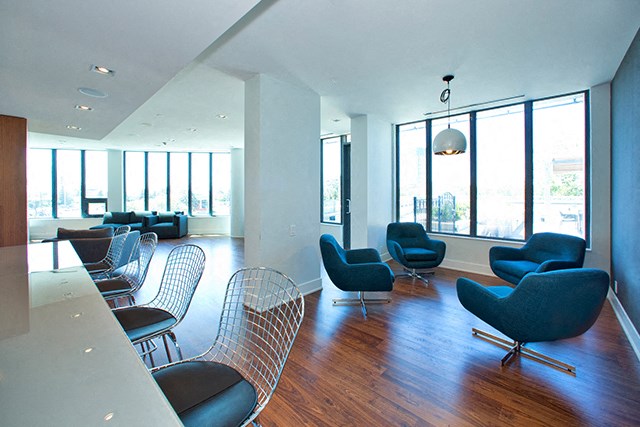 Cityview Apartments Common room with four blue chairs and big windows in Brampton, ON