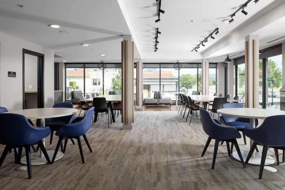 A conference room with blue chairs and a long table at The Ambrosi in Kelowna, BC.