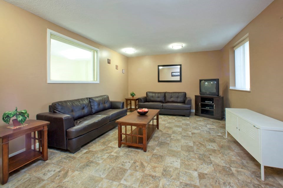 Dorchester Apartments social room with tv and couch seating in Niagara Falls, ON