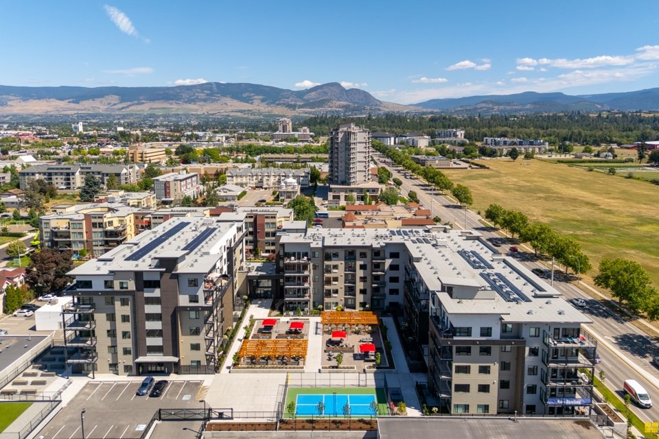 A cityscape with buildings, a pool, and mountains in the distance.