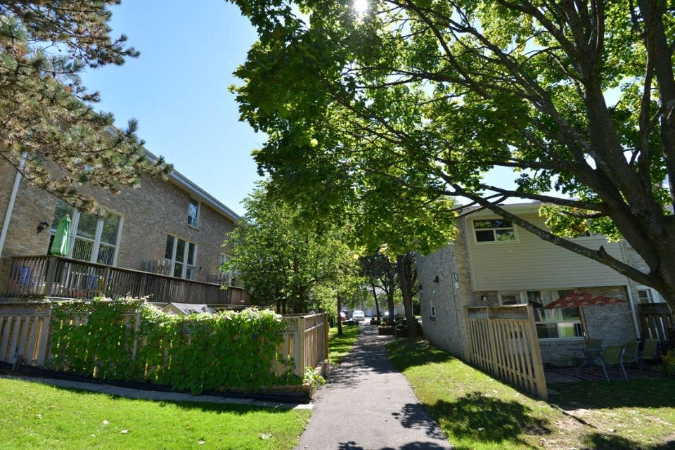 Sidewalk in front of  townhouses and trees  at Creekside Townhomes in Oshawa, ON