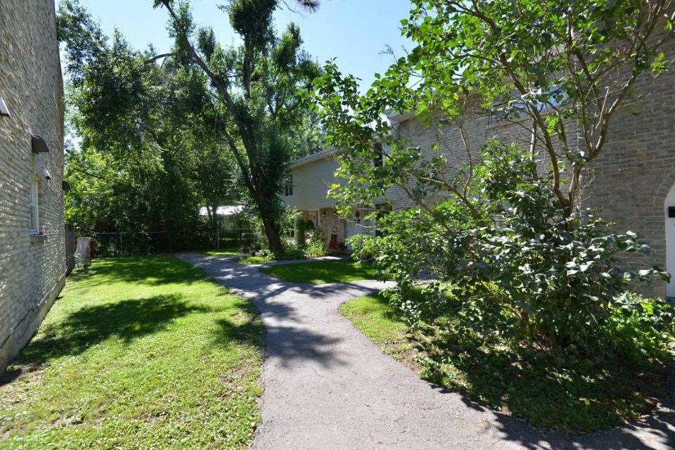 Sidewalk in front of a house with trees  at Creekside Townhomes in Oshawa, ON