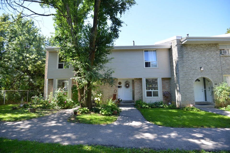 White Brick Townhouse with a Driveway and Trees at Creekside Townhomes in Oshawa, ON