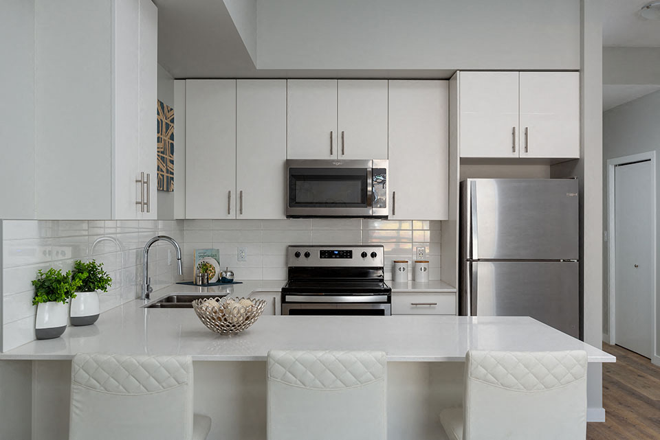A modern kitchen with white cabinets and stainless steel appliances.