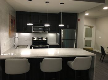 social room with tables, chairs, couch and kitchen at 17 Brookbanks in Toronto ON