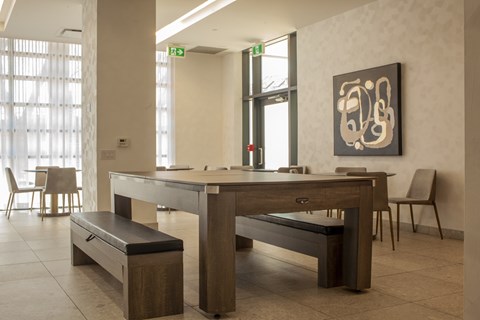 social room with conference table that converts to billiards table at Junction Factory Apartments Toronto ON