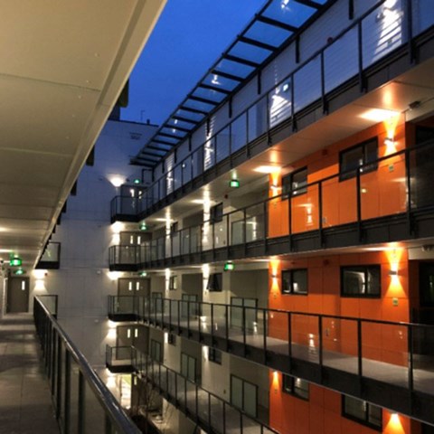 A modern building with orange and black balconies at 388 Kaslo East Village Apartments.