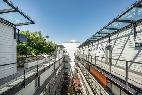 A modern building with a glass roof and a balcony at 388 Kaslo East Village.