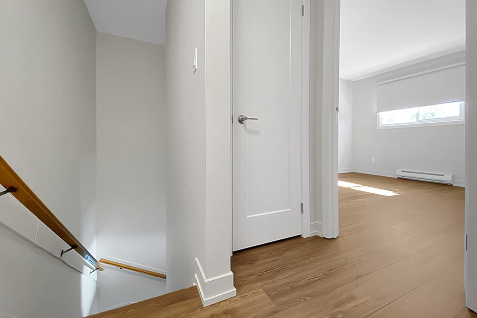 Kensington Apartments landing on second floor showing stairs to first floor, linen closet and primary bedroom