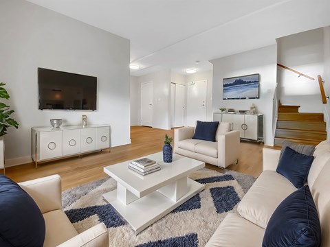 A living room with a white couch and a white coffee table.