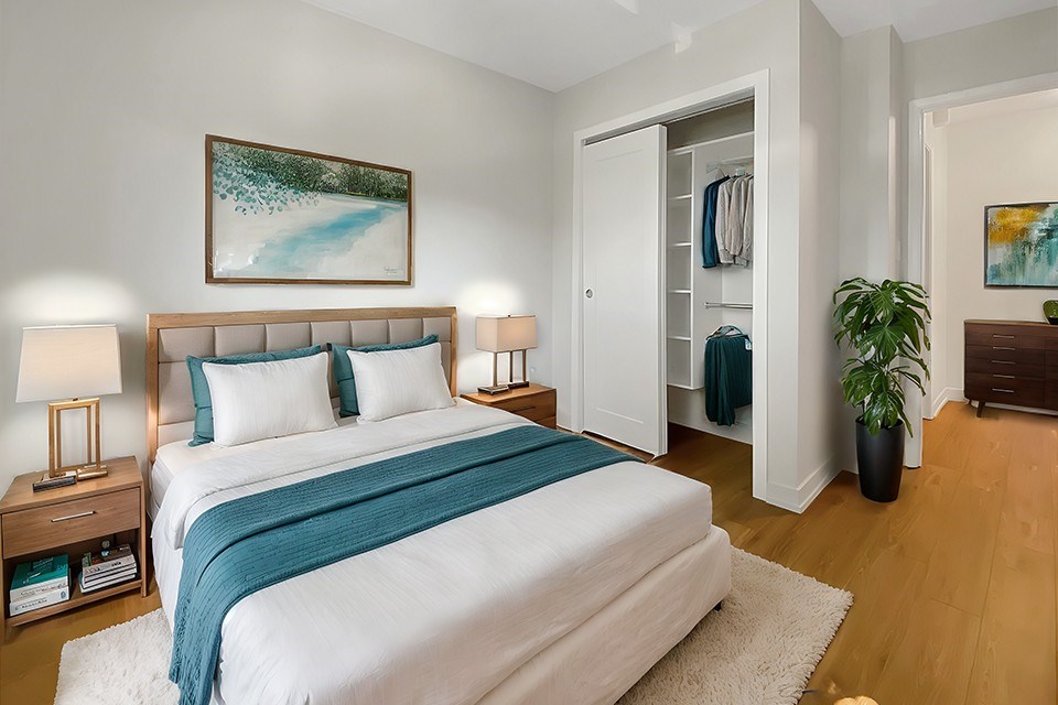 A bedroom with a large bed and a painting on the wall.