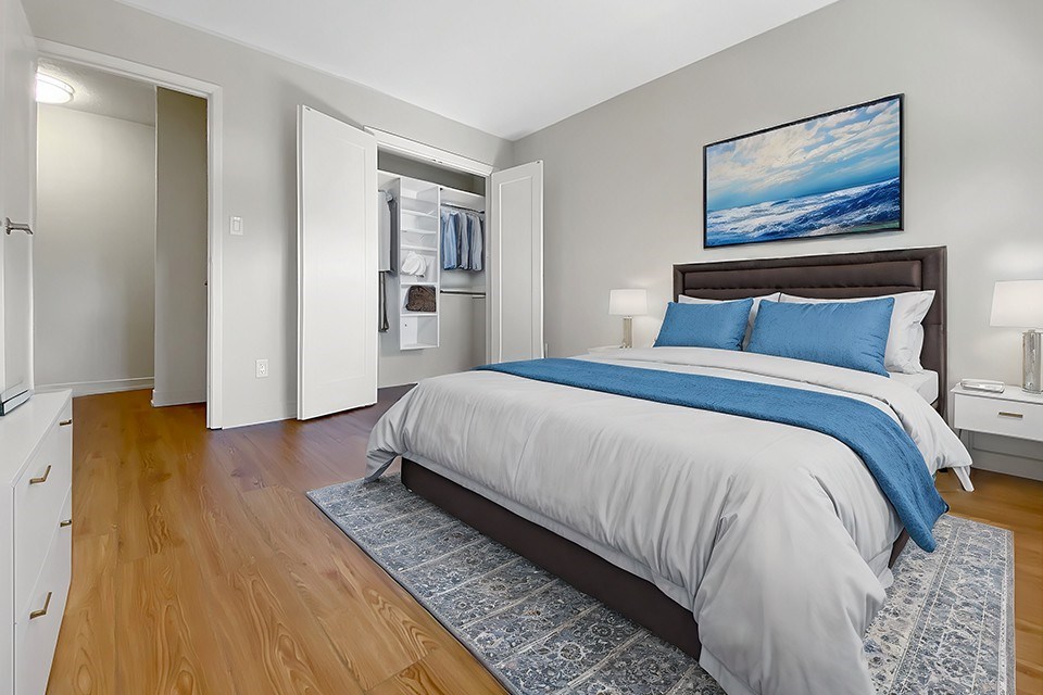 A bedroom with a large bed and a painting on the wall.