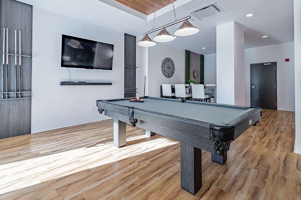 Games room featuring billiards table and luxury vinyl flooring at La Voile Pointe-Claire apartments in Pointe-Claire, Quebec