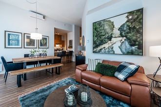 Living and dining room with luxury flooring and modern finishes at La Voile Pointe-Claire apartments in Point-Claire, Quebec