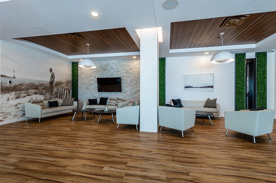 Relaxing social room with padded cube chairs at La Voile Pointe-Claire apartments in Point-Claire, Quebec