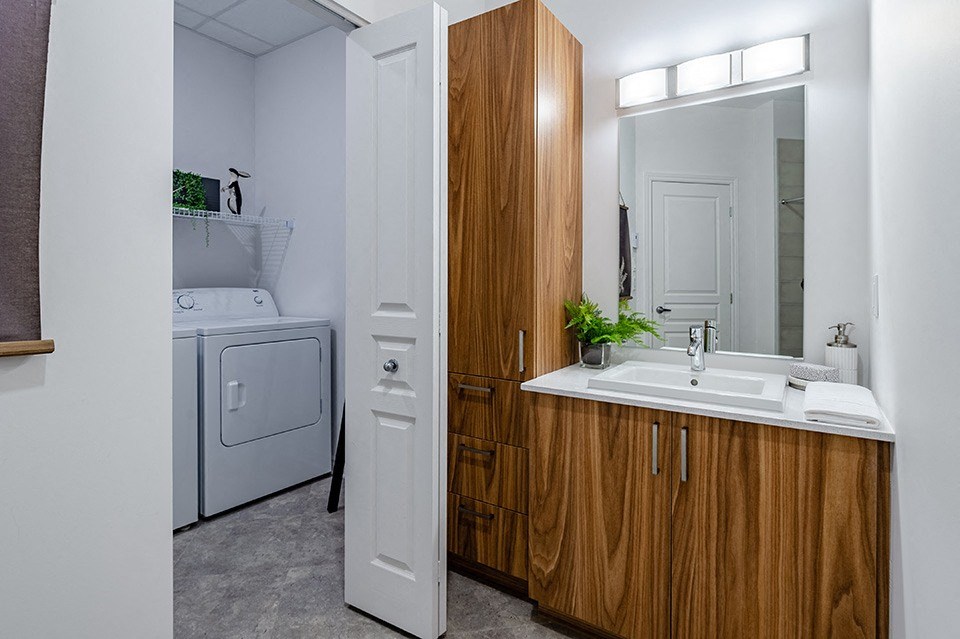 Modern bathroom featuring in-suite laundry at La Voile Pointe-Claire apartments in Pointe-Claire, Quebec