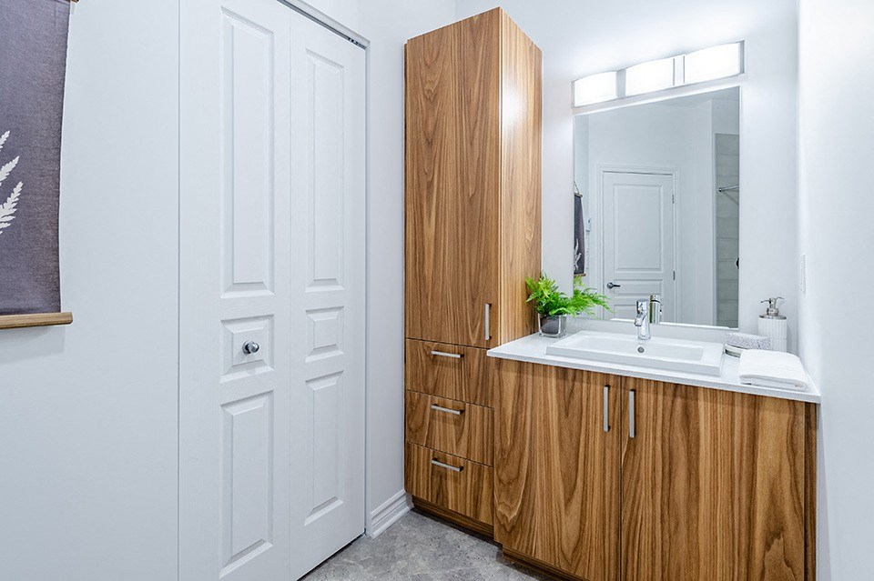 Modern bathroom with wood finishings at La Voile Pointe-Claire apartments in Pointe-Claire, Quebec