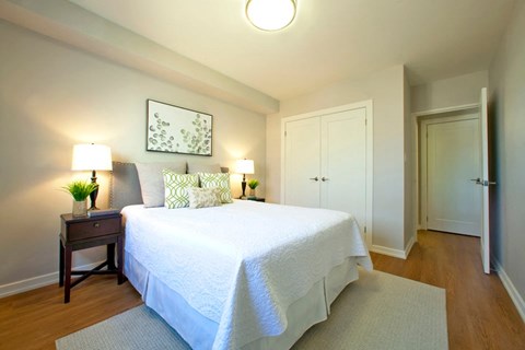A bedroom with a bed, nightstand, and two lamps.