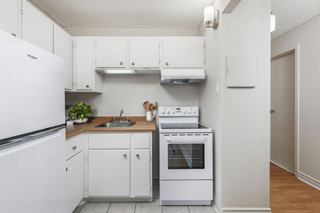 a kitchen with white appliances and white cabinets at Les Jardins Hauterives