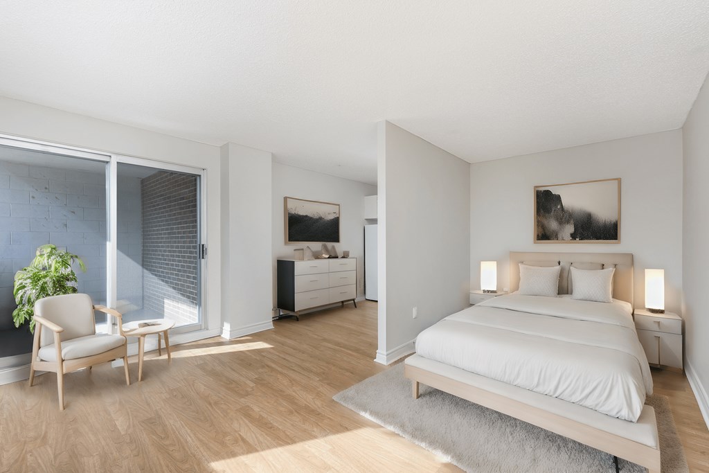 a bedroom with a bed and a chair and a window at Les Jardins Hauterives