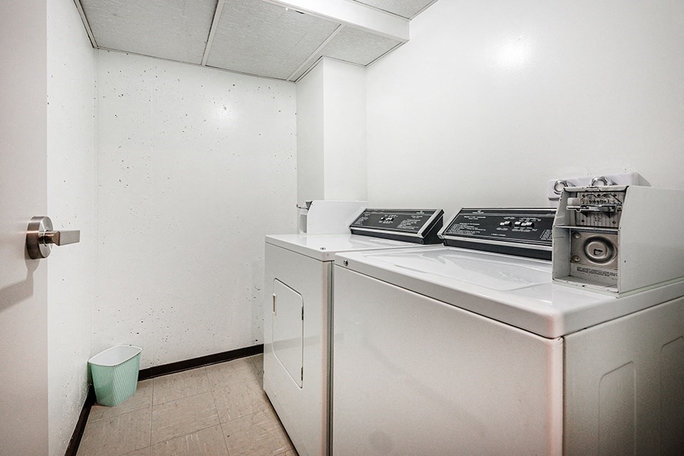 a washer and dryer in a room with a refrigerator and a door