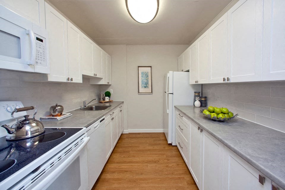 Linden Court kitchen with white cabinetry, full range stove
