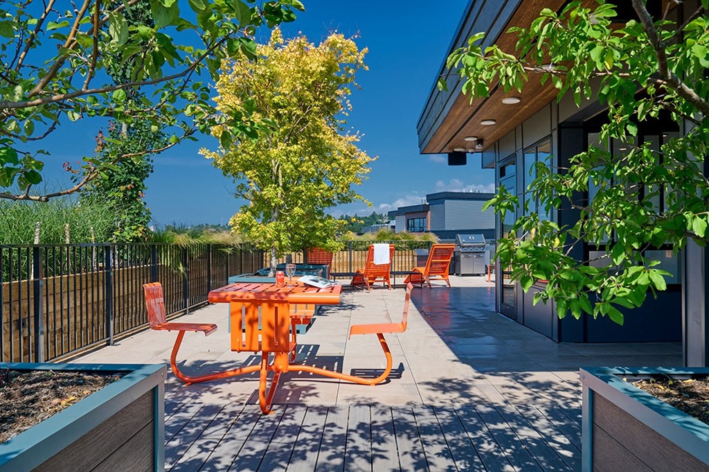 a patio with an orange table and orange chairs