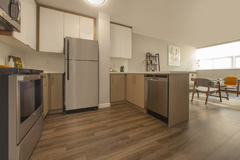 A kitchen with a refrigerator, oven, and microwave.