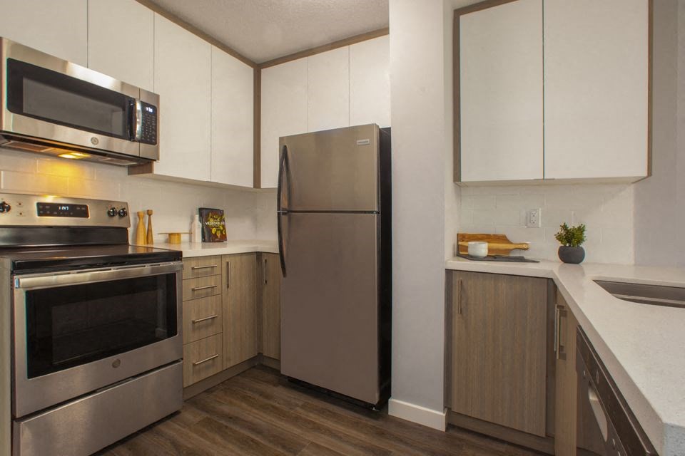 A modern kitchen with a stainless steel refrigerator and oven.