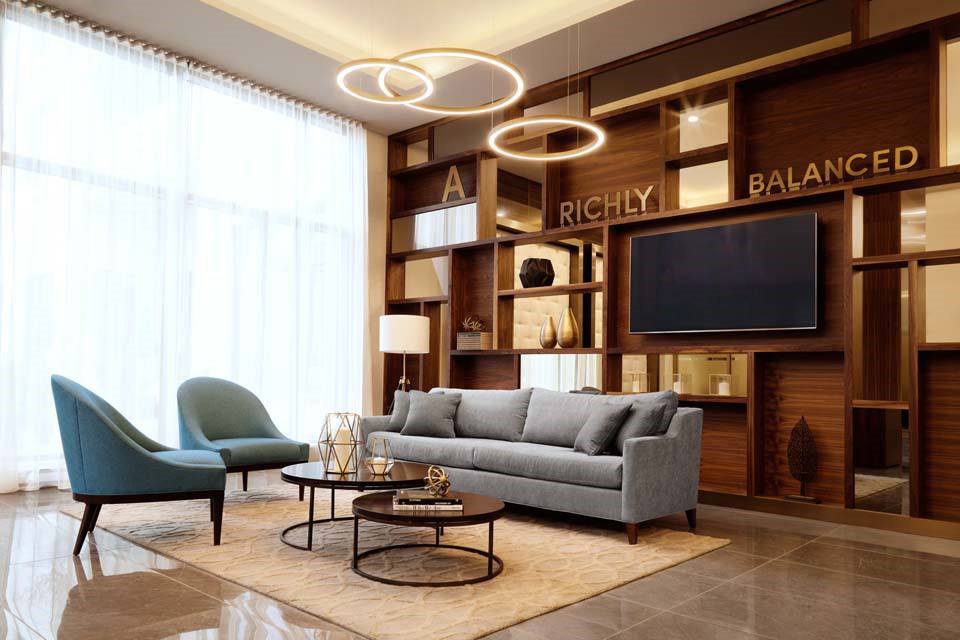 A living room with a grey couch, a green chair, and a coffee table.