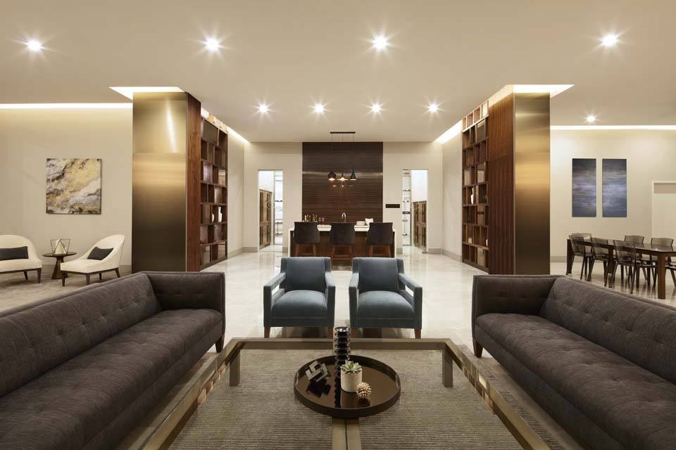 A modern living room with a dark grey sofa and a coffee table in the center.