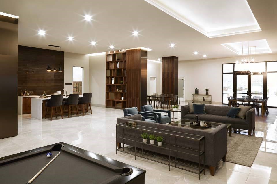 A billiard table is in the middle of a spacious living room.