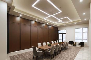 A conference room with a long table and chairs.