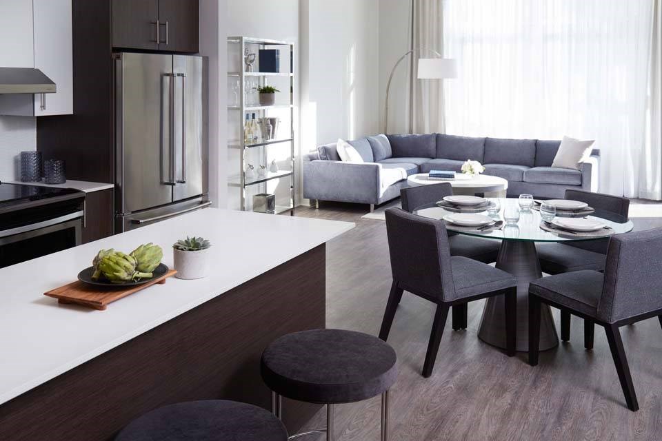 A modern kitchen with a dining table set for two.