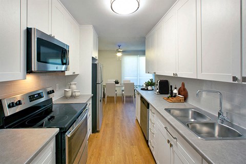 a kitchen with stainless steel appliances and white cabinets