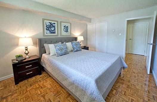 A bedroom with a large bed and two lamps.