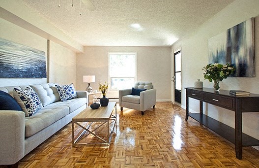 A living room with a couch, coffee table, and a painting on the wall.