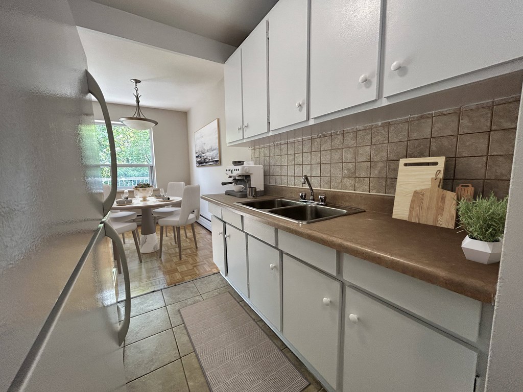 A kitchen with white cabinets and a brown countertop.