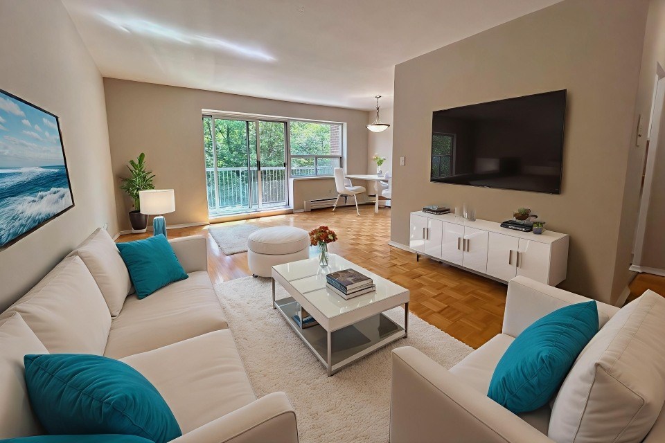 A living room with white furniture and a large painting on the wall.